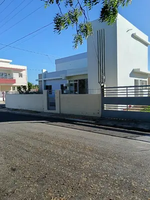 an empty street in front of a white building at Jolie maison in La Romana