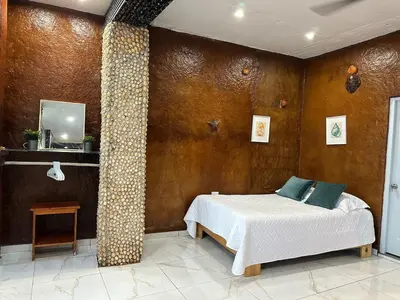 a bedroom with a bed and a large pillar at Guest-House Caracol 2- 4 Pax, vista al mar in Las Galeras