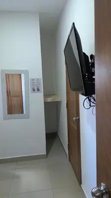 a room with a television and a door with a mirror at Mitaly apartamentos Santo Domingo G in Santo Domingo