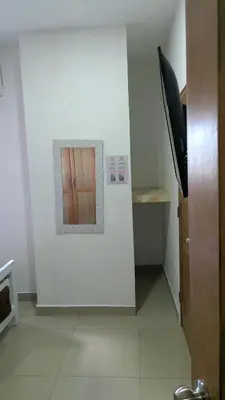 a hallway with a white wall with a small window at Mitaly apartamentos Santo Domingo G in Santo Domingo