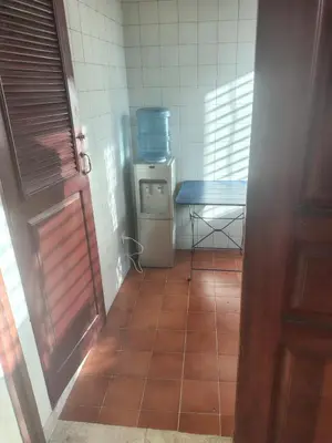 a small kitchen with a table and a tiled floor at Double room with private bathroom in Santo Domingo