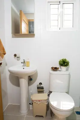 a white bathroom with a toilet and a sink at apartamento vacacional BANI in Boca Canasta