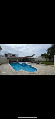 a large swimming pool in front of a building at villa fortuna in Nagua