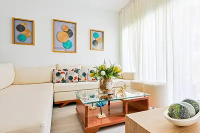 a living room with a couch and a table at Elegant 2BR Apt, Steps to Hard Rock in Punta Cana