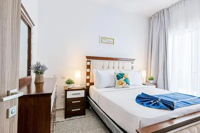 a bedroom with a bed with a blue robe on it at Elegant 2BR Apt, Steps to Hard Rock in Punta Cana