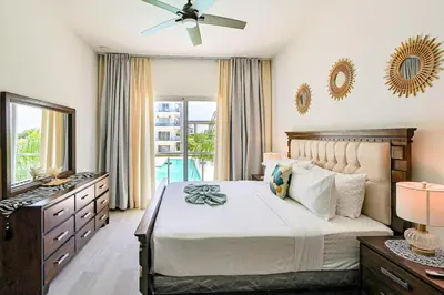 a bedroom with a bed and a dresser and a mirror at Elegant 2BR Apt, Steps to Hard Rock in Punta Cana