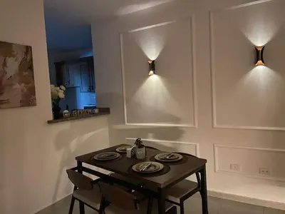 a dining room table with two chairs and two lights at Modern 3-bedroom apartment in a gated residential community in Concepción de La Vega