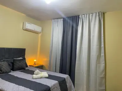 a bedroom with a bed and a window with curtains at Modern 3-bedroom apartment in a gated residential community in Concepción de La Vega