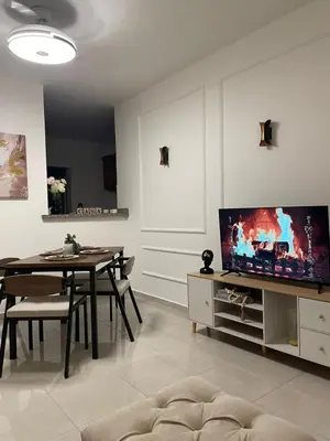a living room with a table and a flat screen tv at Modern 3-bedroom apartment in a gated residential community in Concepción de La Vega