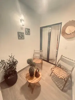 a room with two chairs and a table and plants at El descanso in Higuey