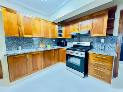 a kitchen with wooden cabinets and a black stove at Luxurious 4 bedroom apartment near the beach in Ensanche Savica de Mendoza