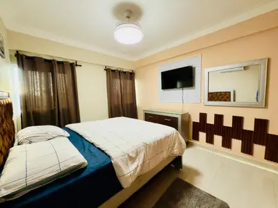 a bedroom with a bed and a tv on the wall at Luxurious 4 bedroom apartment near the beach in Ensanche Savica de Mendoza