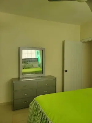 a bedroom with a bed and a mirror on a dresser at Spacious house with private parking in San Felipe de Puerto Plata