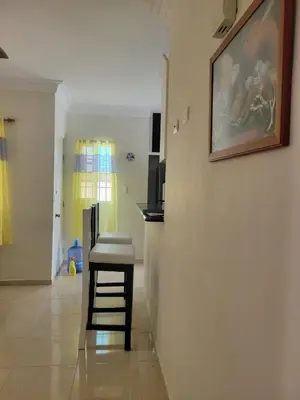 a room with a stool and a painting on the wall at Spacious house with private parking in San Felipe de Puerto Plata