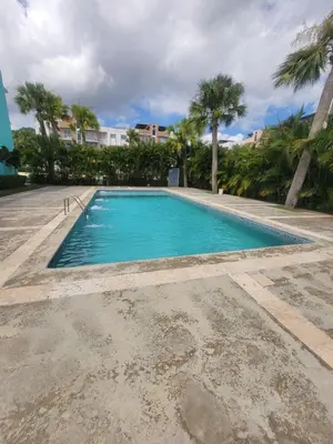 a swimming pool with blue water and palm trees at Palma Real Near Cibao Airport in Santiago de los Caballeros