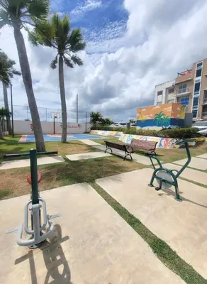a park with a bench and palm trees and the ocean at Palma Real Near Cibao Airport in Santiago de los Caballeros