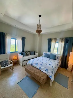 a bedroom with a bed and a couch and windows at JuanDolio Penthouse 3 bedrooms Beachfront frente a hemingway in Los Corrales