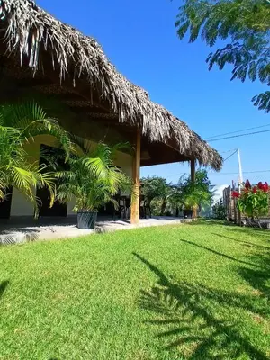 a grass roofed building with a grass yard at APARTAMENTO EXCLUSIVO Villa Privada Flamboyan in Bayahibe