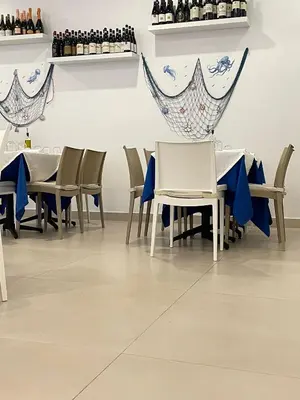a dining room with tables and chairs and wine bottles at Ristorante simaredo in Punta Cana