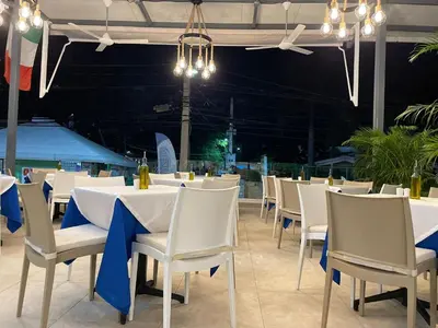 a dining area with white tables and chairs with blue bows at Ristorante simaredo in Punta Cana