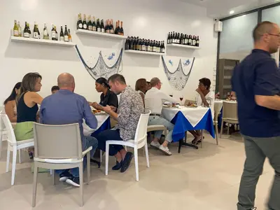 a group of people sitting at tables in a restaurant at Ristorante simaredo in Punta Cana