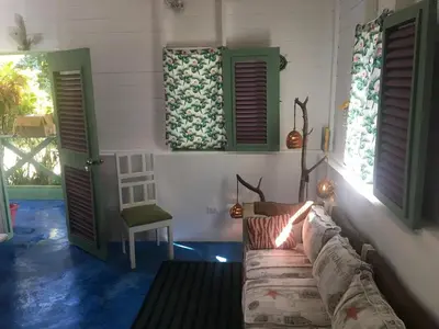 a living room with a couch and two windows at Casa Ylang Ylang, Playa Encuentro in Cabarete