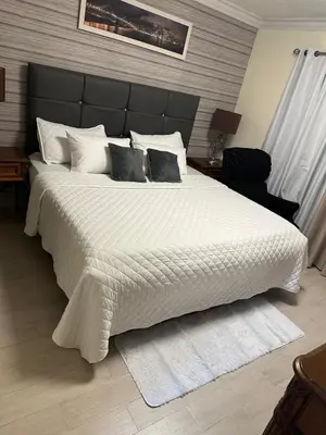 a bedroom with a large bed with white sheets and pillows at Penthouse in Santo Domingo