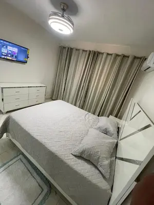 a bedroom with a bed and a tv on the wall at Apartamento acoger en Santo Domingo este in Hainamosa