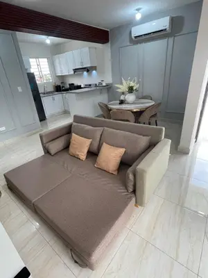 a living room with a couch and a kitchen at Apartamento acoger en Santo Domingo este in Hainamosa