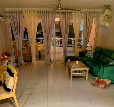 a living room with a green couch and a table at Karibisches Familienparadis in Gated Comunity in Sosua