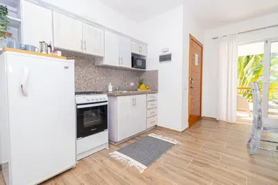 a kitchen with white cabinets and a white refrigerator at Luxury 1BR Oasis Paraiso Residence Bayahibe