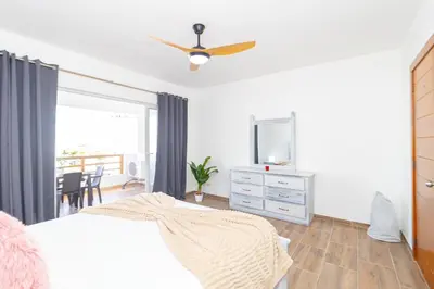 a bedroom with a bed and a tv and a dresser at Luxury 1BR Oasis Paraiso Residence Bayahibe