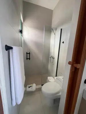 a small bathroom with a toilet and a shower at Beautiful Penthouse in Sunset Puerto Plata Gym, Pool in Puerto Plata