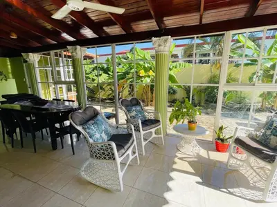 a conservatory with a table and chairs and a dining room at 360 View House with Private Pool Jacuzzi and Terrace in Puerto Plata