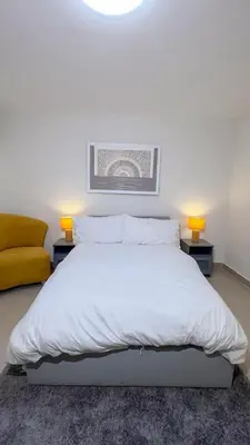 a bedroom with a large white bed with two lamps at San Isidro Urban suite in Juan López