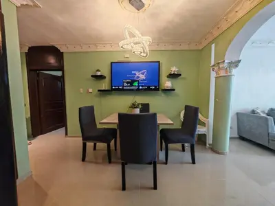 a dining room with a table and chairs and a tv at 3 Bed, 2 Bath, Hot Water, Apartment near the beach, in Bani in Baní