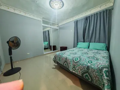 a bedroom with a bed with green sheets and a window at 3 Bed, 2 Bath, Hot Water, Apartment near the beach, in Bani in Baní