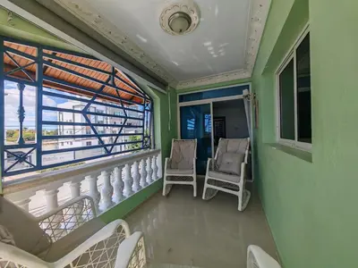 a balcony with two chairs and a window at 3 Bed, 2 Bath, Hot Water, Apartment near the beach, in Bani in Baní