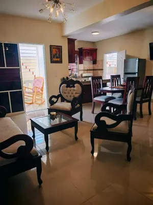 a living room with chairs and tables and a kitchen at Cozy apartment, AC, Wifi, 2 Bedroom, 2 bath, Bani, 1-A in Baní