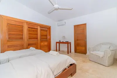 a bedroom with a bed and a chair and a ceiling fan at Las Marinas Los Nmada, 80 meters from Coson beach in Las Terrenas