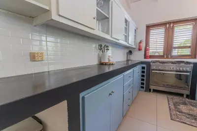 a kitchen with white cabinets and a black counter top at Tropical Villa in Playa Bonita in Pasos Del Mar in Las Terrenas