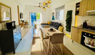 a kitchen and living room with a table and a couch at Modern Central Ocean View and Jacuzzi Apartment in Santo Domingo