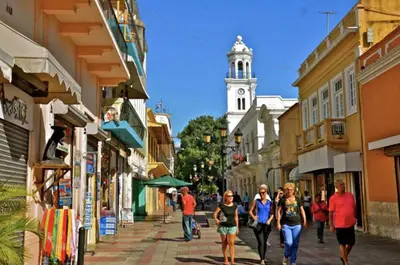 a group of people walking down a street with a clock tower at Modern Central Ocean View and Jacuzzi Apartment in Santo Domingo