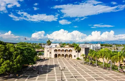 a view of a building in a city with palm trees at Modern Central Ocean View and Jacuzzi Apartment in Santo Domingo