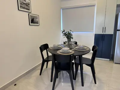 a black dining room table with chairs in a kitchen at Prado Garden Hotel in Monte Plata