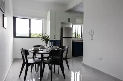 a kitchen and dining room with a table and chairs at Prado Garden Hotel in Monte Plata