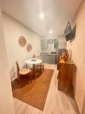a room with a table and chairs and a kitchen at El descanso in Mata Chalupe