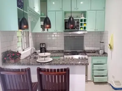 a kitchen with green cabinets and a counter top at Casa Brisa del Río in Las Terrenas