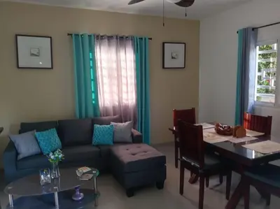 a living room with a blue couch and a table at Casa Brisa del Río in Las Terrenas