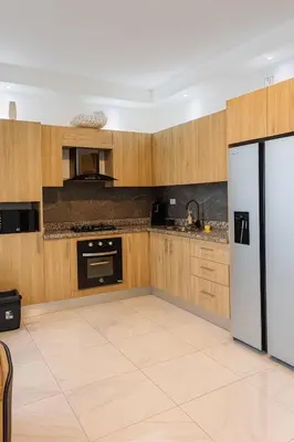 a kitchen with wooden cabinets and a refrigerator at Boca chica playa y sol in Boca Chica